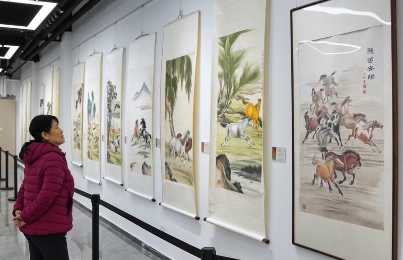 陶然亭公园，“百花齐放、万马奔腾——赵又弘国画展”，一位游客驻足欣赏骏马主题国画。新京报记者 薛珺 摄