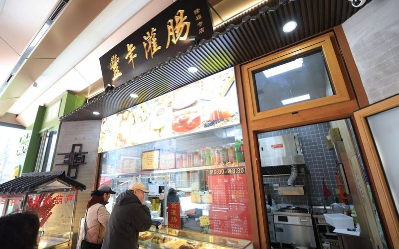 2月11日，隆福寺丰年灌肠，市民正在窗口选购小吃。新京报记者 王飞 摄