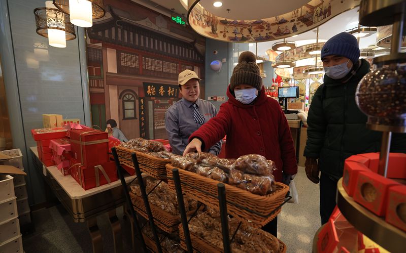 2月11日，隆福寺稻香村，不少市民前来询问总书记购买的三款年味小食，工作人员正在介绍。新京报记者 王飞 摄