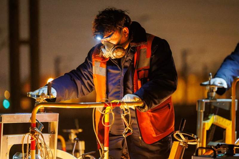 工人一边推动打磨机一边观察作业情况。