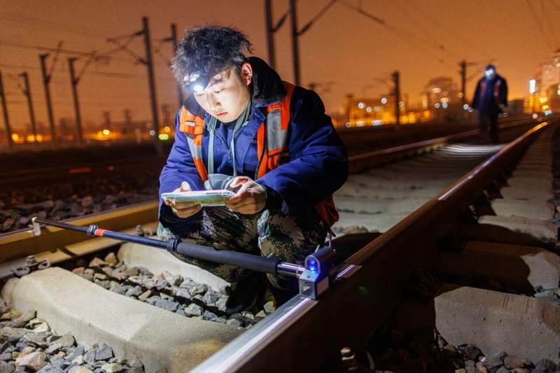 工人测量钢轨轮廓。