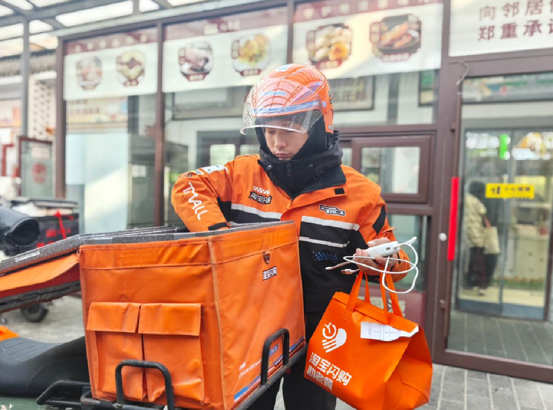 淘宝闪购骑手正在配送助老餐。