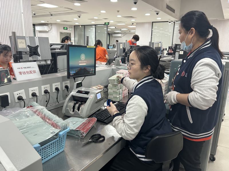 工行北京分行工作人员正在为线上预约取新钞的客户配款。姜樊 摄