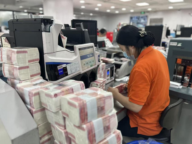 银行工作人员正在清分百元新钞。据了解，一名工作人员1个小时可清分新钞25捆，即250万元。姜樊 摄