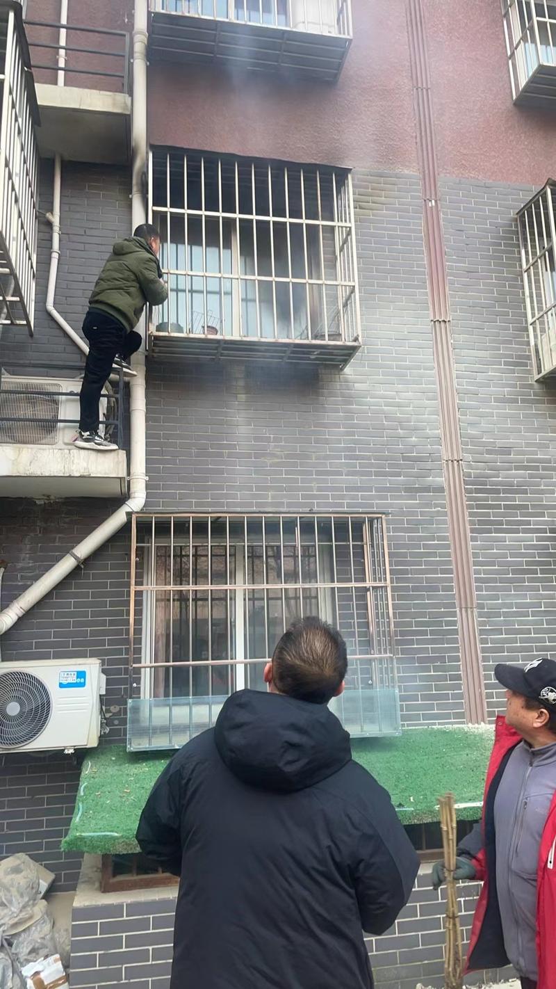 李树奎果断借助室外护栏攀爬至二层，手持灭火器对准火源根部喷射。大兴消防供图