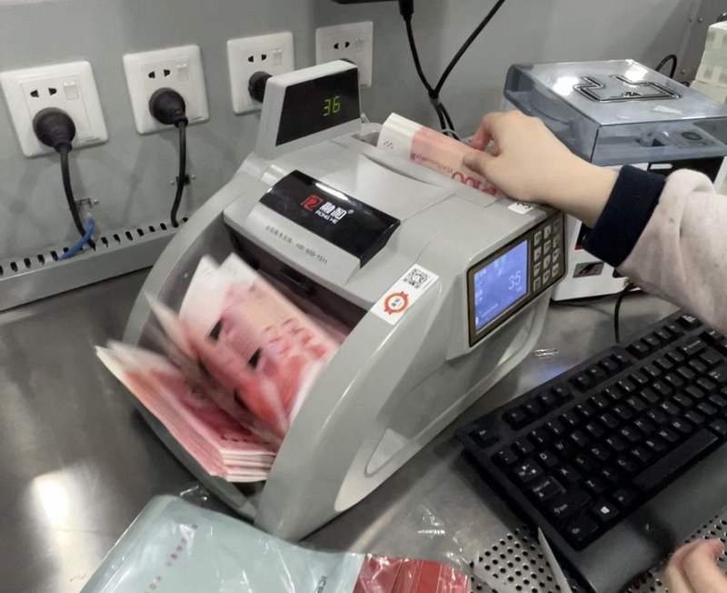 银行工作人员用点钞机点钞。姜樊 摄