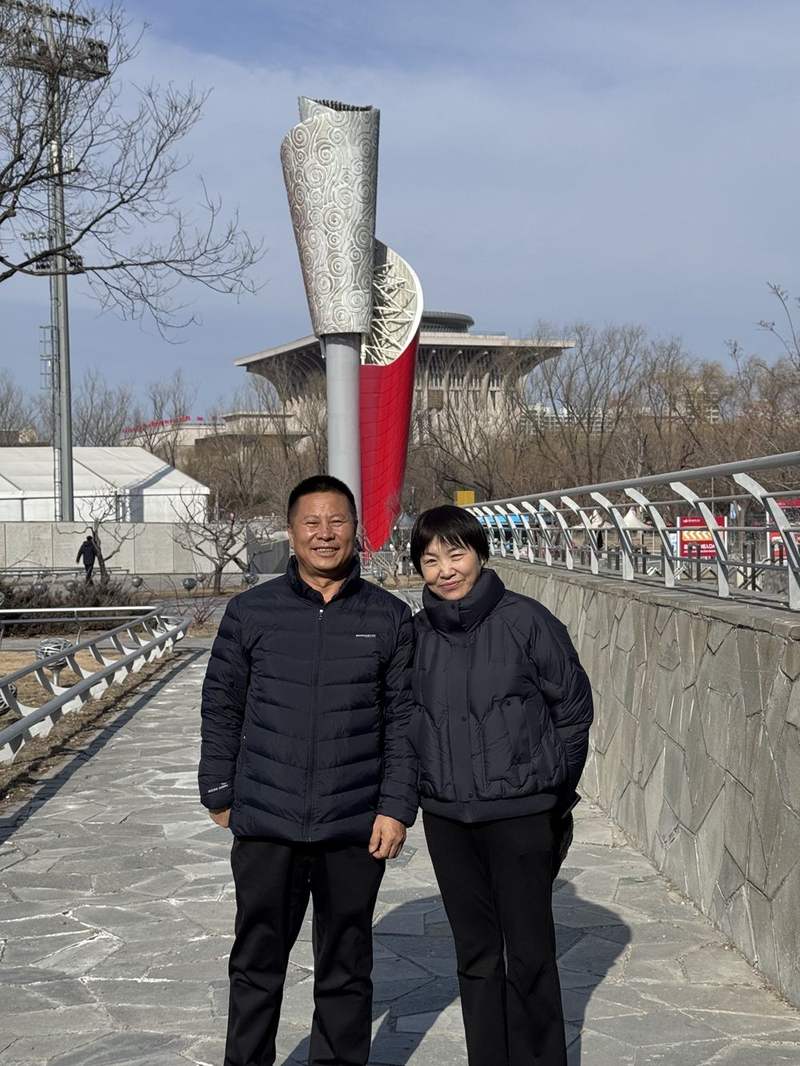 杨怀玉的父母与北京奥运火炬合影。受访者供图