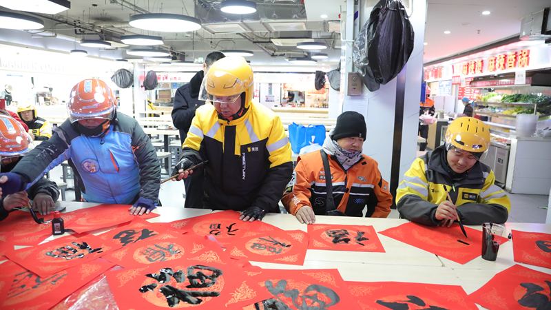 网约配送员正在写“福”字。海淀区市场监管局供图