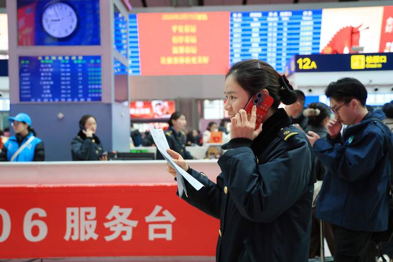 在北京南站12306服务台前，李玲沟通协调工作。新京报记者 王远征 摄