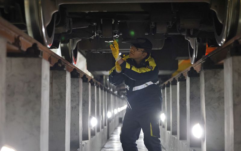 检修地沟空间狭小，李易需要手持强光手电进行检查。新京报记者 王贵彬 摄