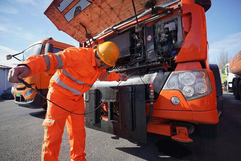 张华正在检查一台大型工程车辆的机油卡尺。新京报记者 王贵彬 摄