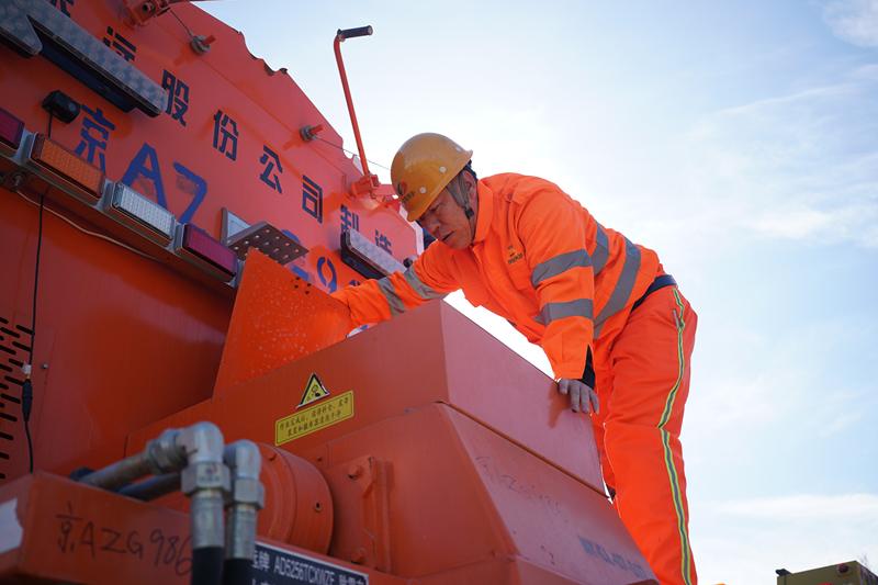 张华爬上一辆除雪车，查看融雪剂储备情况。新京报记者 王贵彬 摄