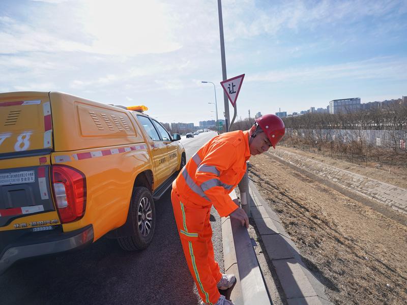 张华查看路面设施情况。新京报记者 王贵彬 摄