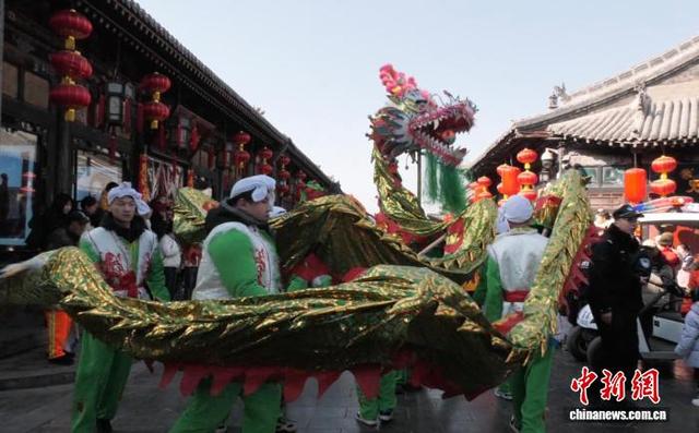 2月17日，山西平遥古城南大街上，舞龙队伍穿梭古城之中。马维秀 摄