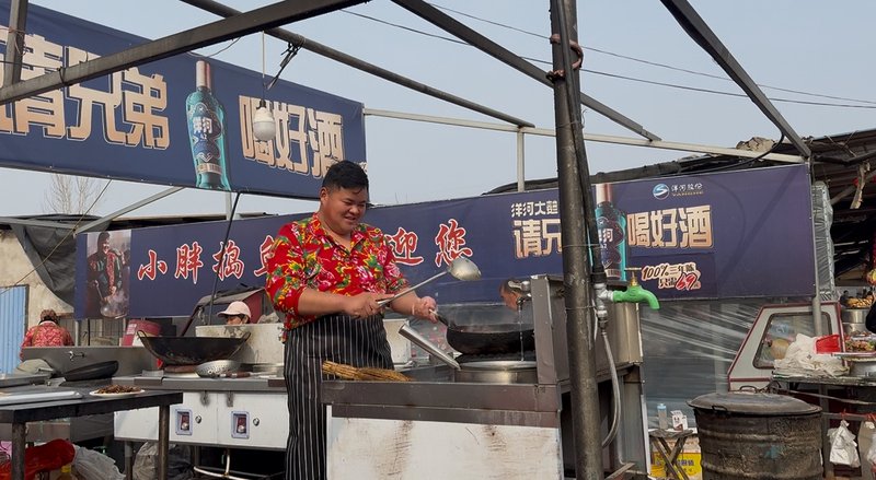 2月15日，农历腊月二十八，“捣鱼刺小胖“正在炒菜。 新京报记者 赵敏 摄