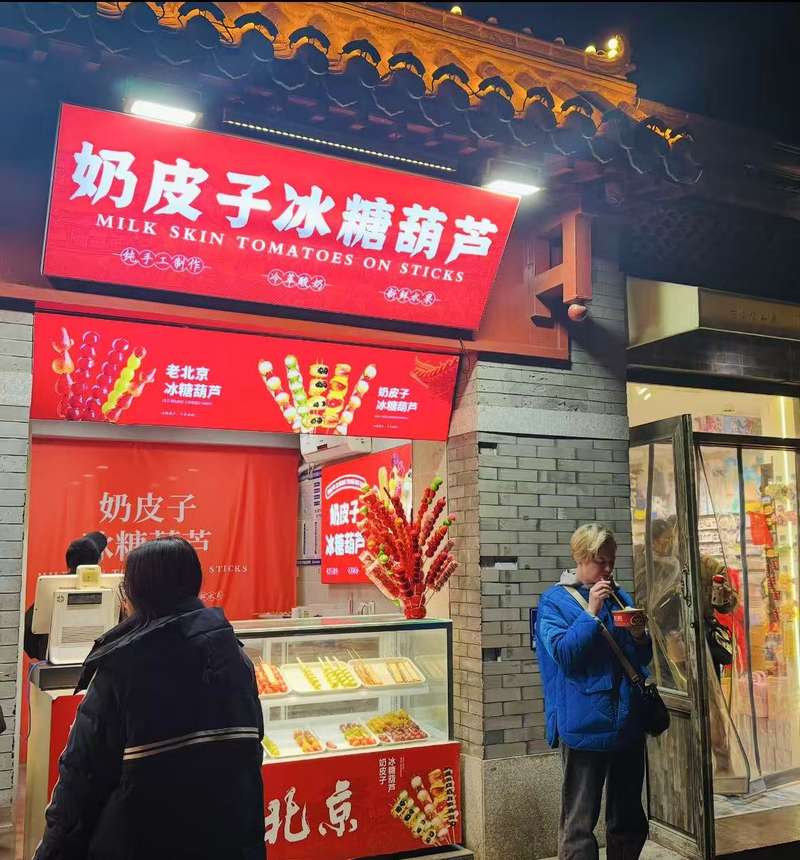 外国游客在南锣鼓巷品尝蟹黄汤包。新京报贝壳财经记者王真真 摄