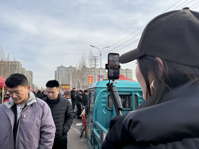 2月16日，农历腊月二十九早上八点左右，临沭县曹洼大集，一位主播正在直播赶集。 新京报记者 赵敏 摄