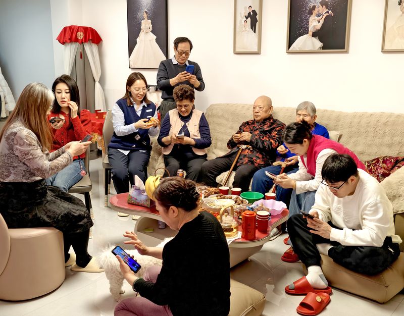 ▲2月16日除夕夜，北京某市民一大家，围坐在电视机前看春晚、抢红包。图/IC photo