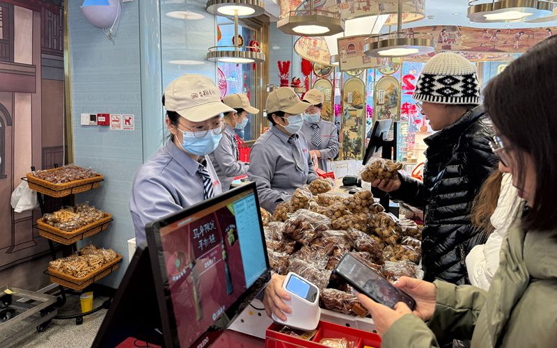 2月20日，北京稻香村门店，市民游客在购买总书记同款年货“三件套”。新京报记者 陈琳 摄