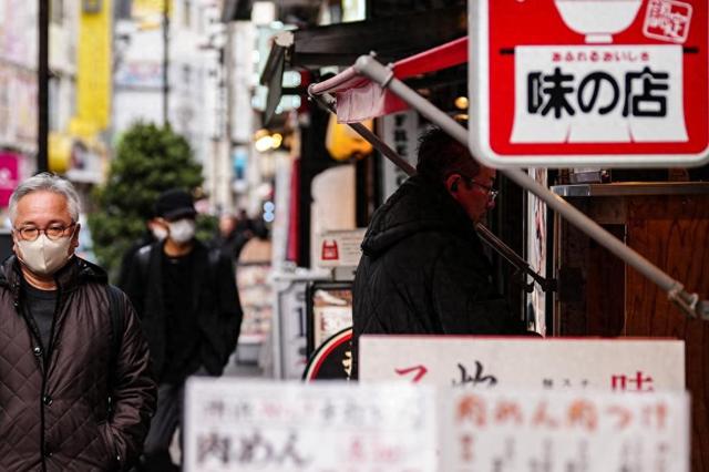 2月20日，在日本东京，顾客在一家餐厅门口购买餐券。新华社记者贾浩成摄