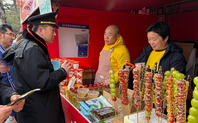 2月21日，龙潭庙会，崔杰关注到摊主出售的冰柿子在常温下保存，要求其尽快把冰箱搬来。新京报记者 陈琳 摄