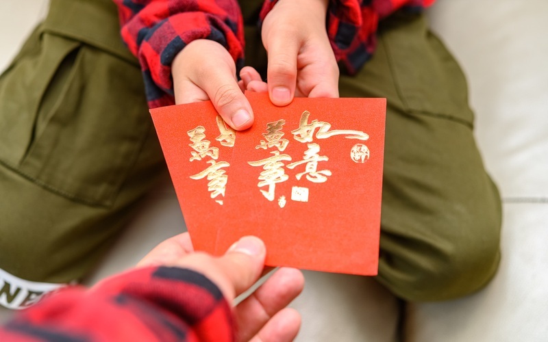 ▲资料图：爸爸给儿子压岁钱。图/IC photo
