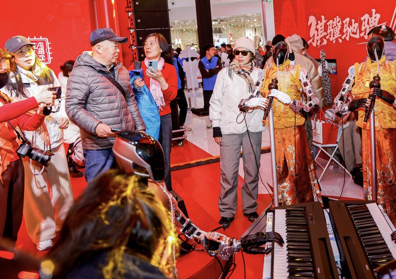 2月19日，在海淀新春科技庙会上，市民和机器人乐队合影。新京报记者 浦峰 摄