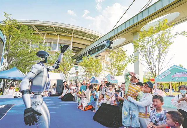 2025年5月1日，在武汉光谷空轨高新通衢站，东说念主形机器东说念主与旅客互动。湖北日报全媒记者 魏铼 摄