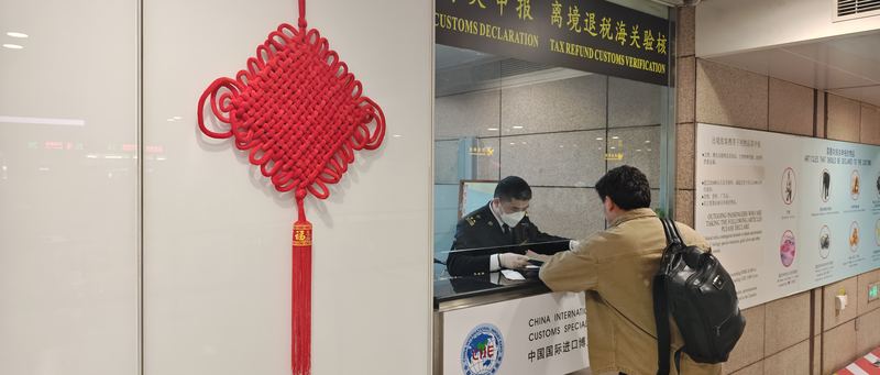 上海浦东机场海关关员为旅客办理离境退税验核业务。受访者供图