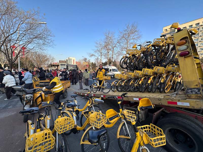 早高峰时段，共享单车运维人员正抓紧调度，清理地铁站外淤积车辆。新京报记者 王贵彬 摄