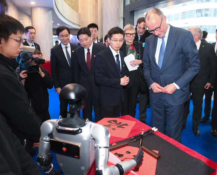 2月26日，德国总理默茨在杭州宇树科技观看机器人写“福”字。新华社记者 翁忻旸 摄