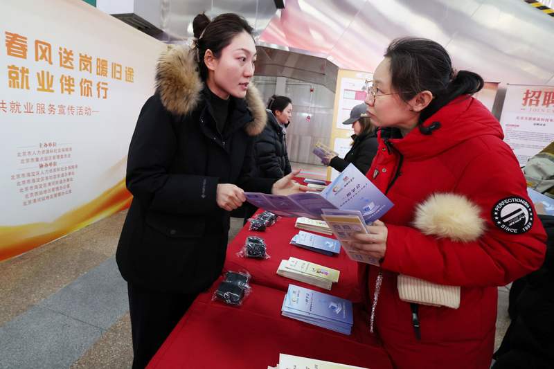2月27日，北京西站，工作人员为求职者发放招聘信息。新京报记者 王贵彬 摄