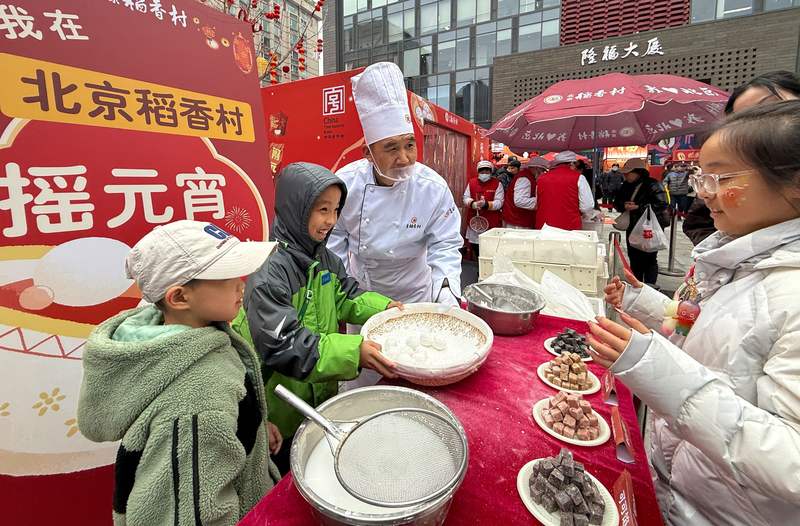 小朋友在隆福寺新春市集体验摇元宵。新京报记者 王贵彬 摄