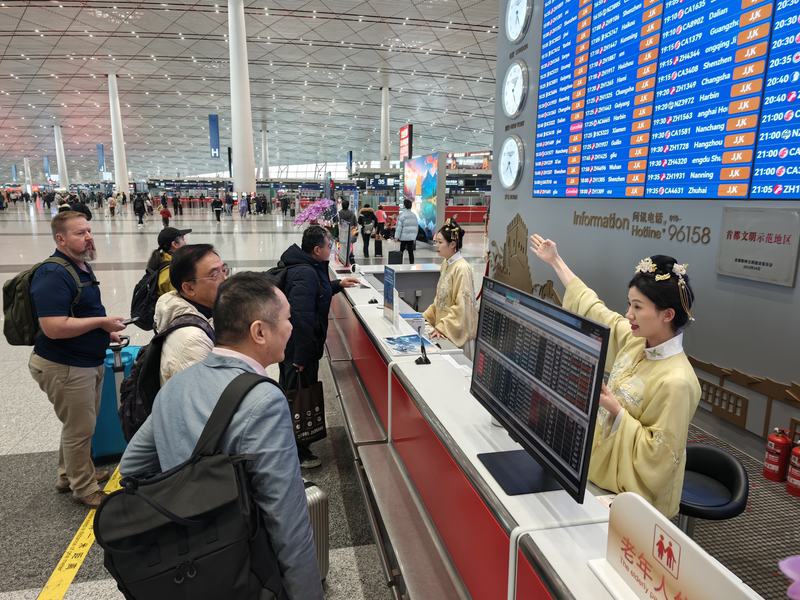 首都机场，身穿汉服的工作人员为乘客服务。新京报记者 王巍 摄