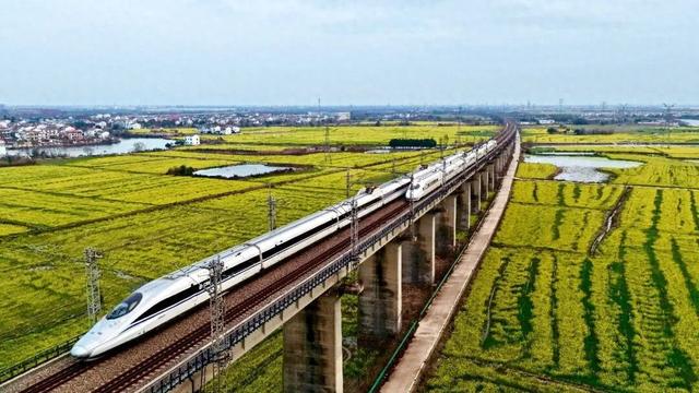 2月27日，江西南昌县，高铁列车从油菜花田边驶过。王超摄