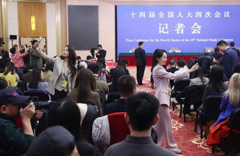 3月8日，梅地亚中心，外交主题记者会开始前，女记者提前开始工作。