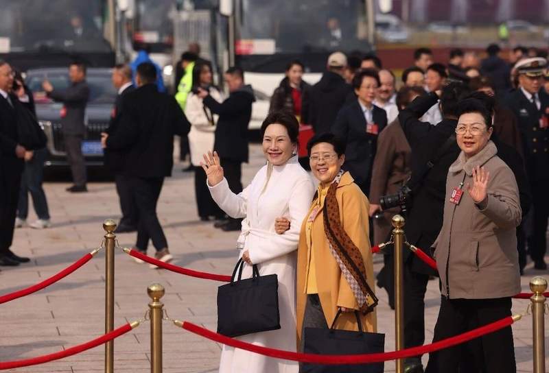 3月7日，天安门广场，参加全国政协十四届四次会议第二次全体会议的女政协委员向记者挥手致意。