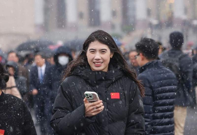3月4日，参加十四届全国人大四次会议预备会的全国人大代表张雨霏走在瑞雪中。