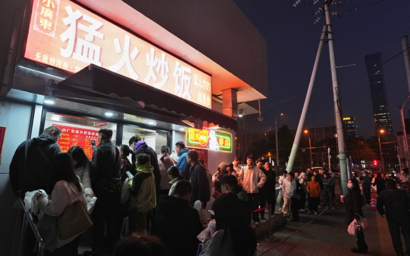 ▲北京朝阳，食客在“小广东猛火炒饭”门店前排队等待取餐。图/IC photo