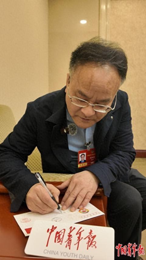 3月9日，全国政协委员、上海科技馆馆长倪闽景给中学生写下寄语。中青报·中青网见习记者 赵晨霖/摄