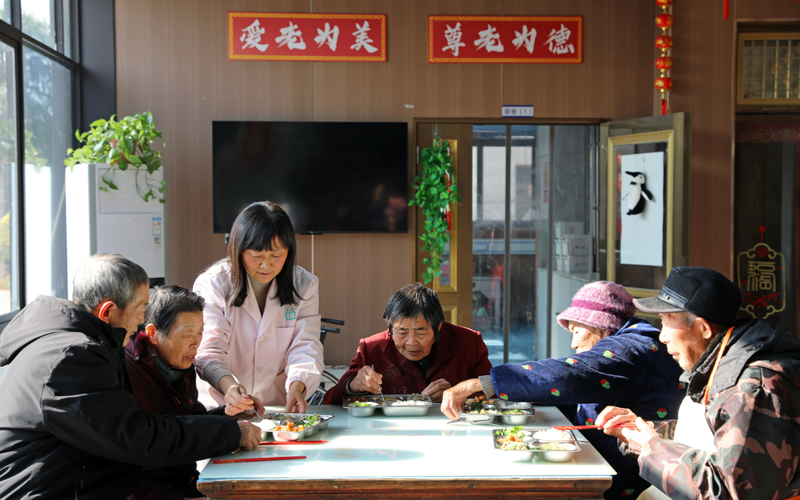 ▲资料图：护理人员在照顾老人用餐。图/新华社