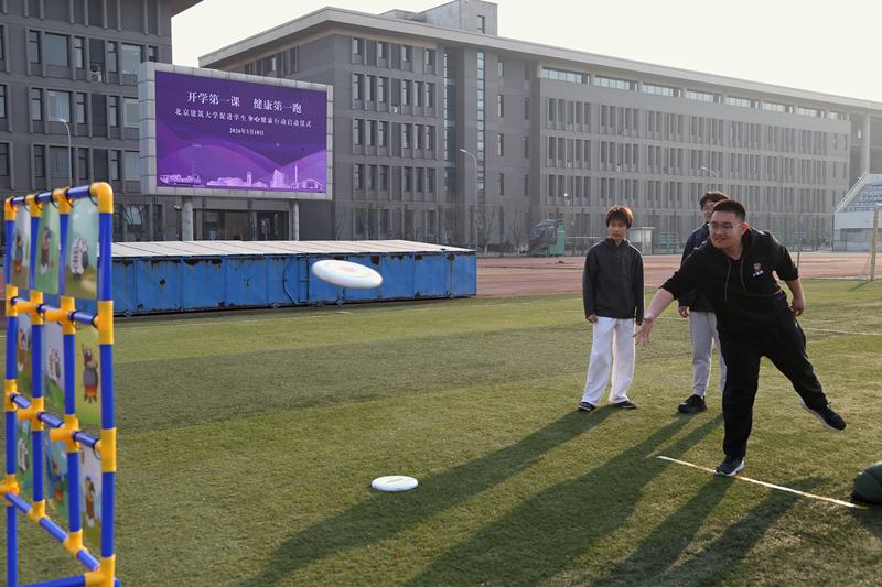 3月10日，北京建筑大学操场，学生们在跑步后体验飞盘等体育运动。图/北京教育融媒体中心