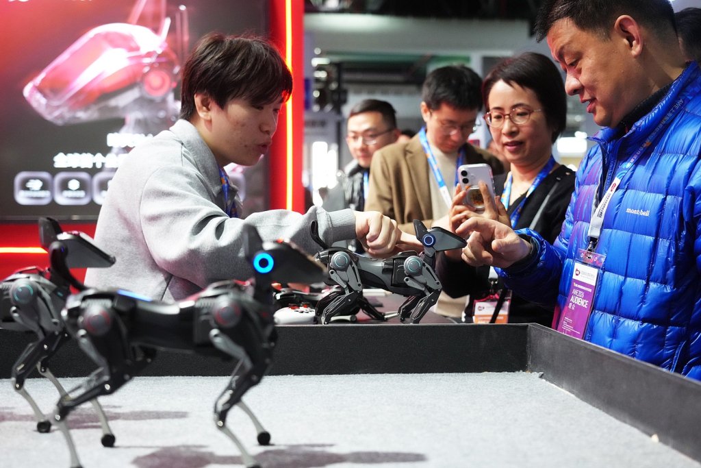 2026年3月12日，2026中国家电及消费电子博览会在上海开幕。图为小型陪伴机器狗吸引观众围观。中新社记者 张亨伟 摄