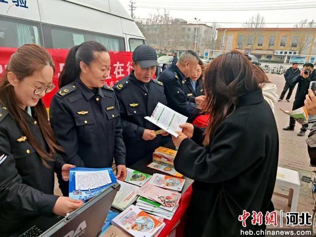 图为工作人员为群众讲解消费维权常识。 杨晓薇 摄