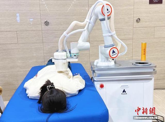 图为观众体验智能艾灸机器人的艾灸服务。 卢琪 摄