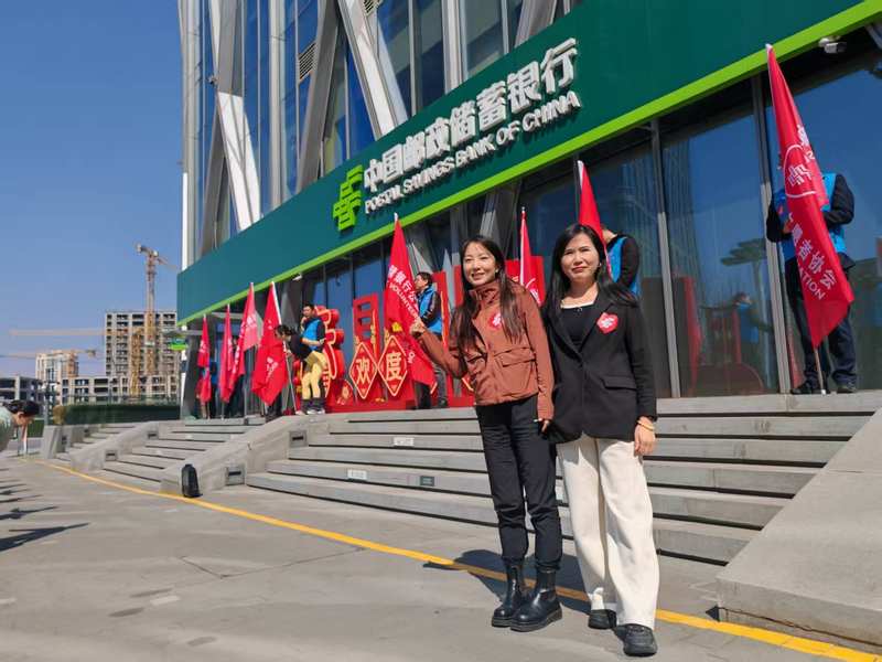 邮储银行北京通州区支行李冰（左）与邮储银行北京分行网络金融部肖利元（右）在“邮爱公益”活动现场。企业供图