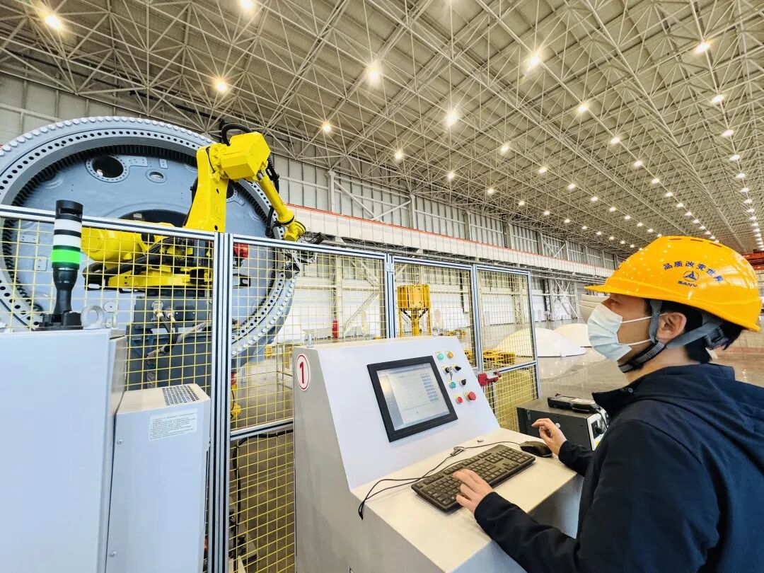 车间内，工人在操作轮毂螺栓自动拧紧设备，目前已进入试生产阶段。