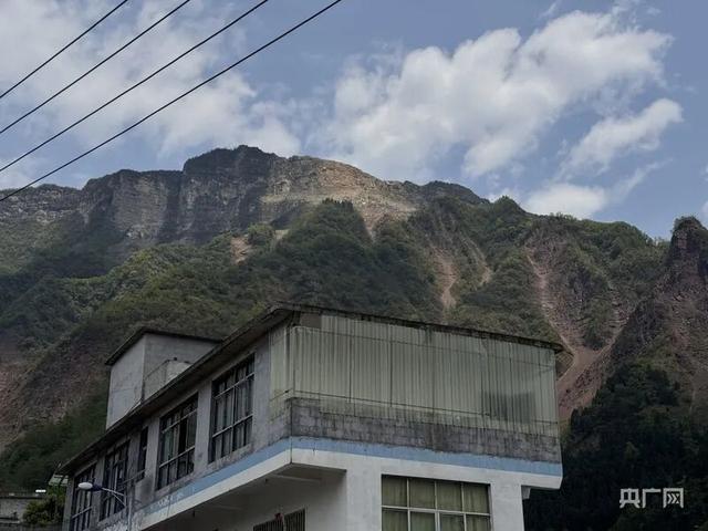 坡脚村山脚下的村民房屋（总台中国之声记者管昕 摄）