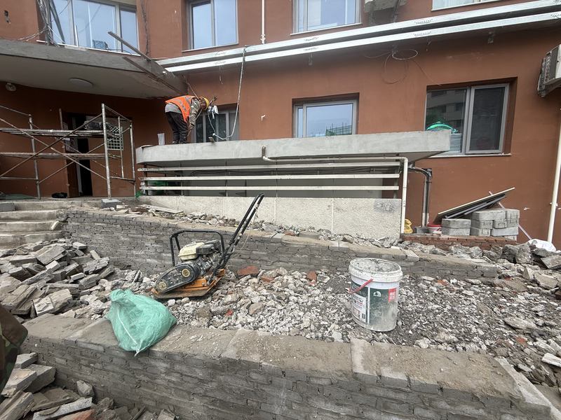 4月17日，朝阳区东大桥东里12号楼单元门前，工人正在拆除“之”字形坡道。新京报记者 曹晶瑞 摄