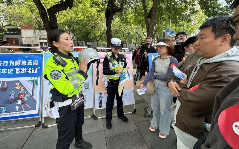 铁骑交警向市民讲解如何挑选适合自己的头盔，并展示如何规范佩戴。新京报记者 王贵彬 摄